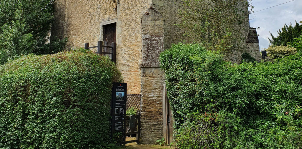 Entrance to Longthorpe tower surrounded by green hedges