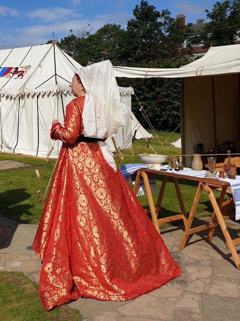 Woman dressed in red medieval gown and veil