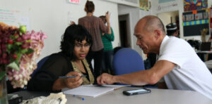 A mentor sits with a social enterprise owner, offering help and guidance
