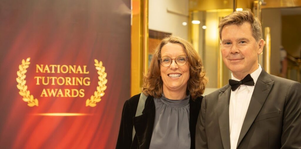 Rob and Lynne Kerrison beside the National Tutoring Award logo