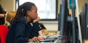 Young student sits in front of computer