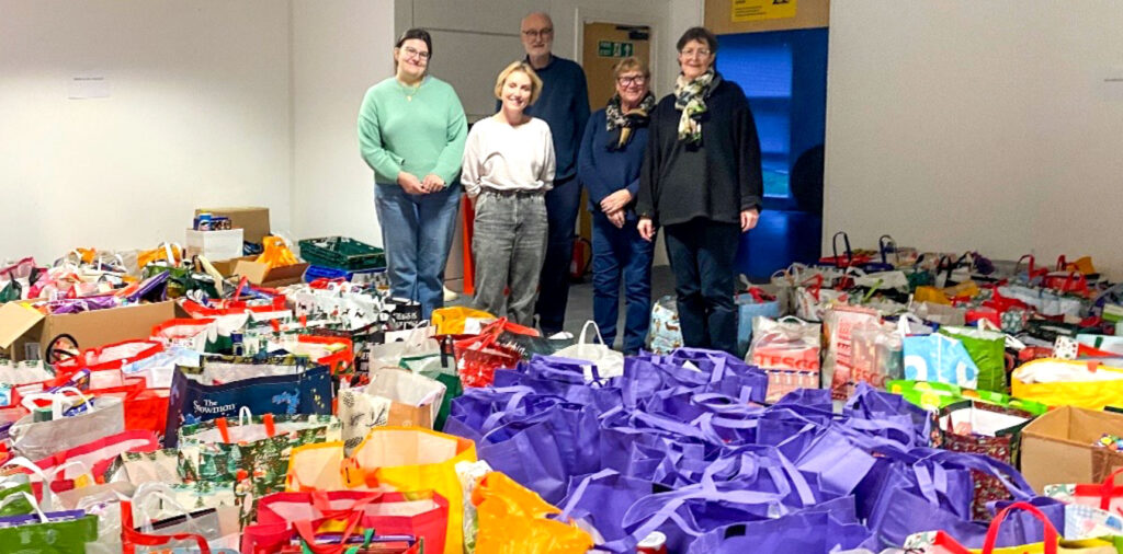 Foodbank volunteers with some of the food and items donated for Christmas Hampers
