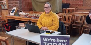 Volunteer seated ready to offer benefits and financial advice